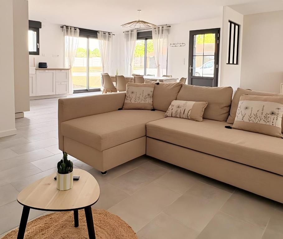 a living room with a couch and a table at Gite Ô’Violetis in Domvast