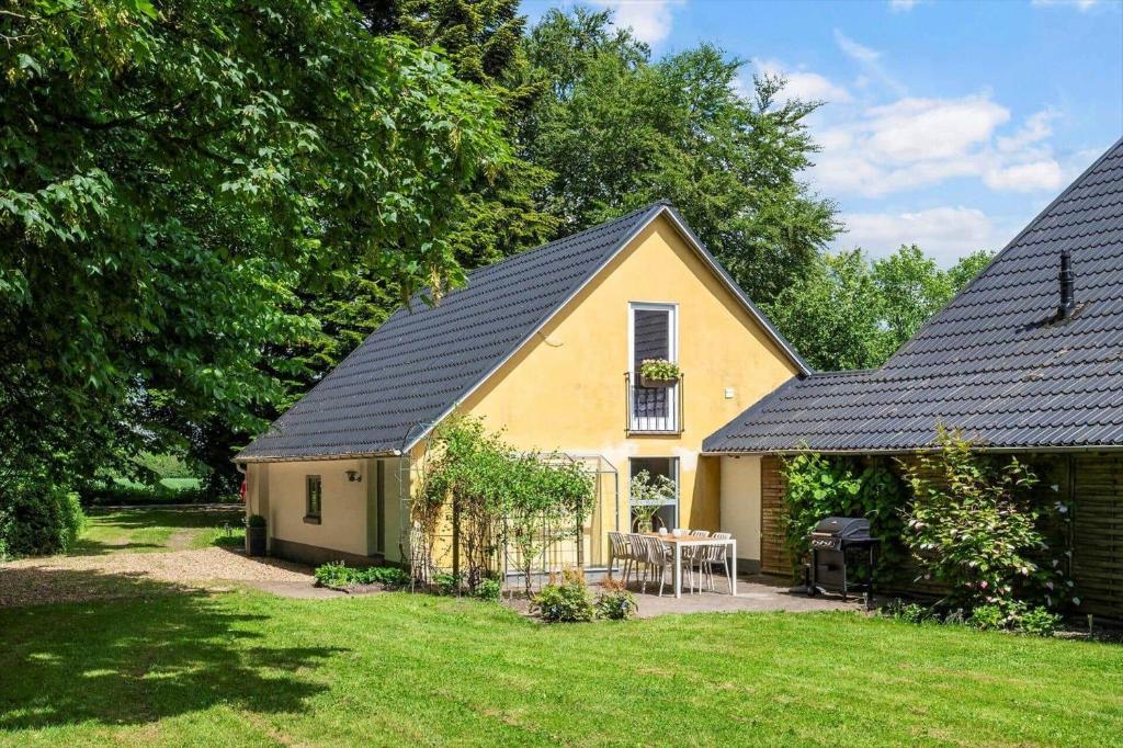 a yellow house with a table in a yard at SJ342-Vamdrup-Holtvej-11-sommerhus in Vamdrup