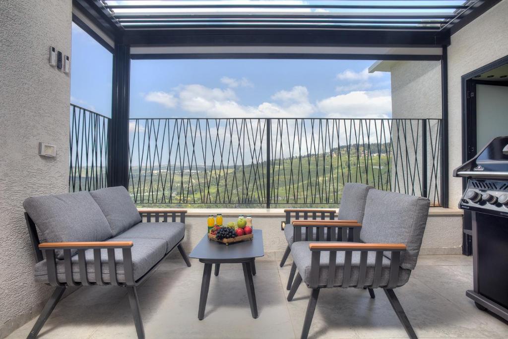 two chairs and a table on a balcony with a view at דיאמנט - Diamond in Safed