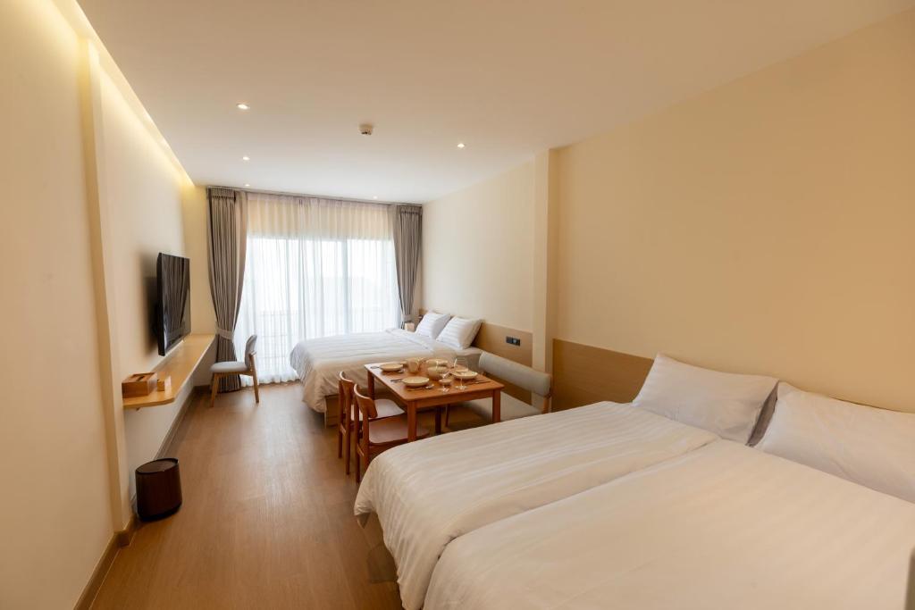 a hotel room with two beds and a table at Acoz in Ban Zong Katiam