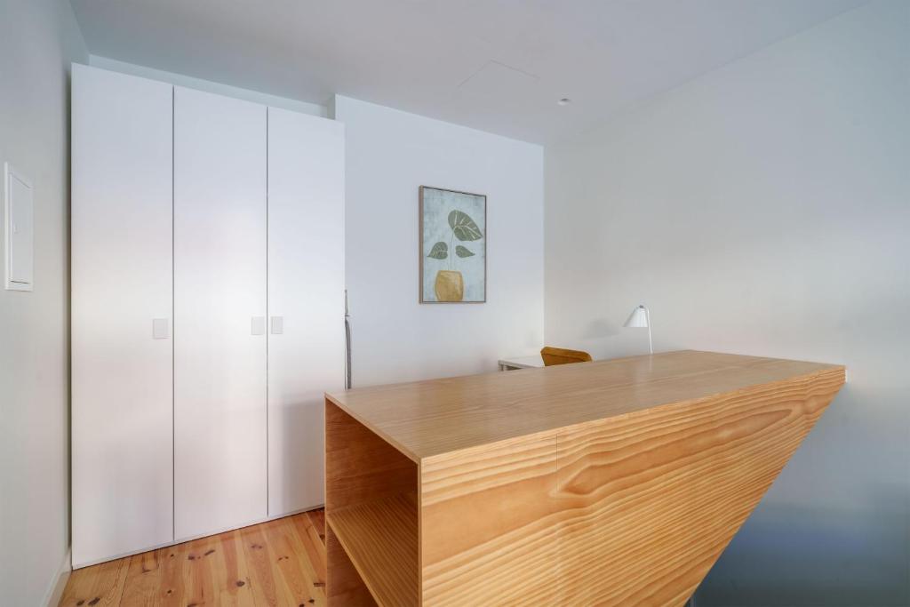 a wooden desk in a room with white walls at Figueirinhas Home Green in Coimbra