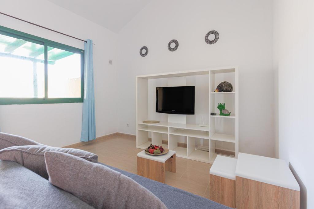 a living room with a couch and a tv at Blue Río Playa, Casa & Studio in Costa Calma
