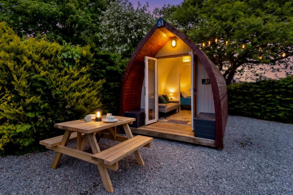 a small tent with a picnic table and a bench at The Hideaway - Tranquil Glamping Pod in Narberth