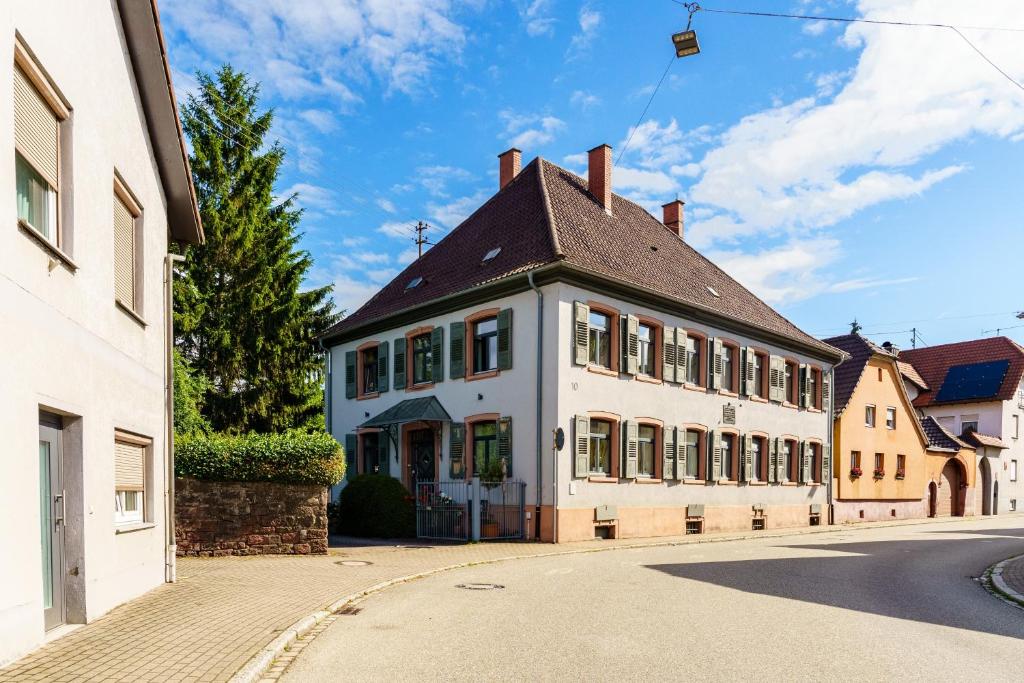 a large white building with a brown roof at Pfarrgarten in Kippenheim