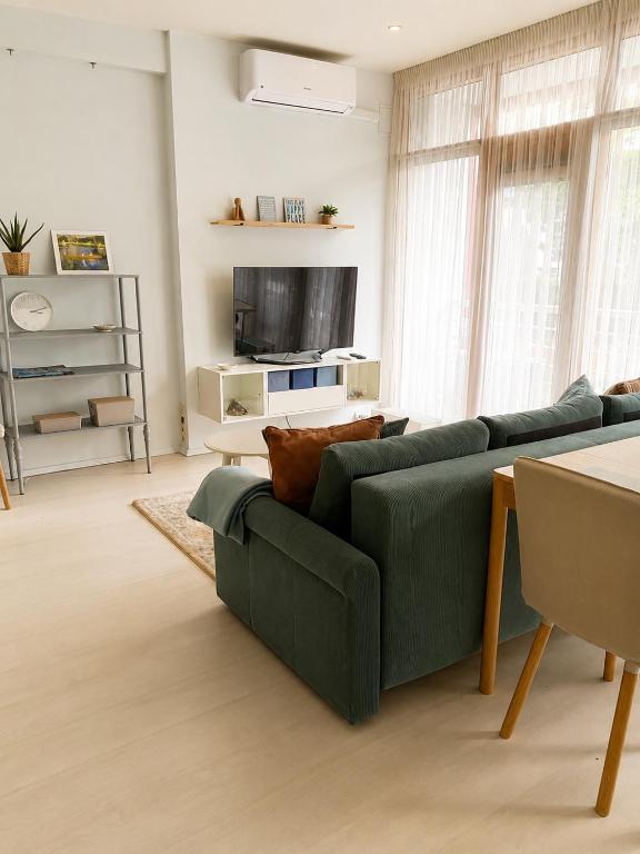 a living room with a green couch and a television at SeaSand in Jūrmala