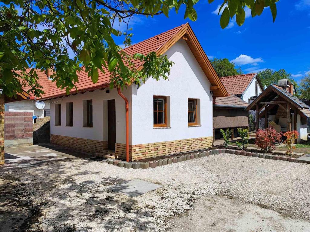 a white house with a red roof at Strázsa Porta in Monor