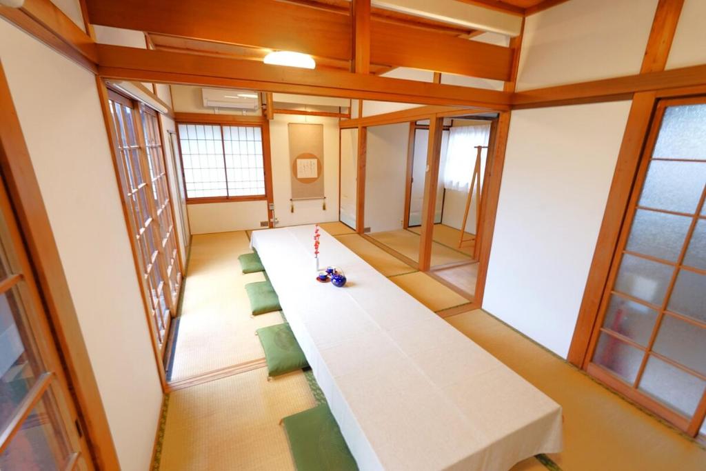 a conference room with a long table and green chairs at YADOOR名張 -kominka- in Nabari