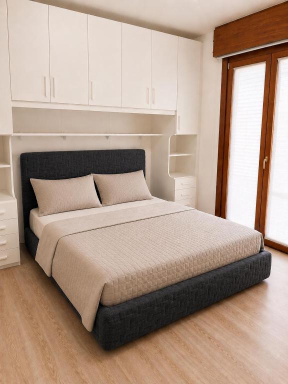 a bedroom with a large bed with white cabinets at residenza MINERVA & swimming pool in Aprilia Marittima