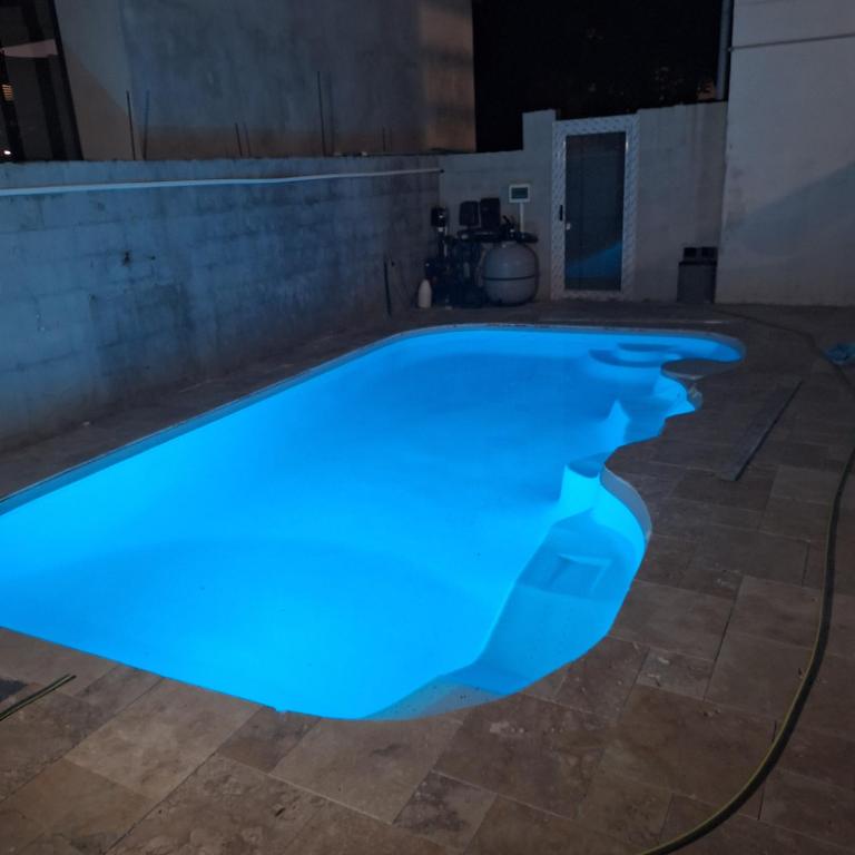 ein nachts blau beleuchtetes Schwimmbecken in der Unterkunft vavane in L’Étang-Salé