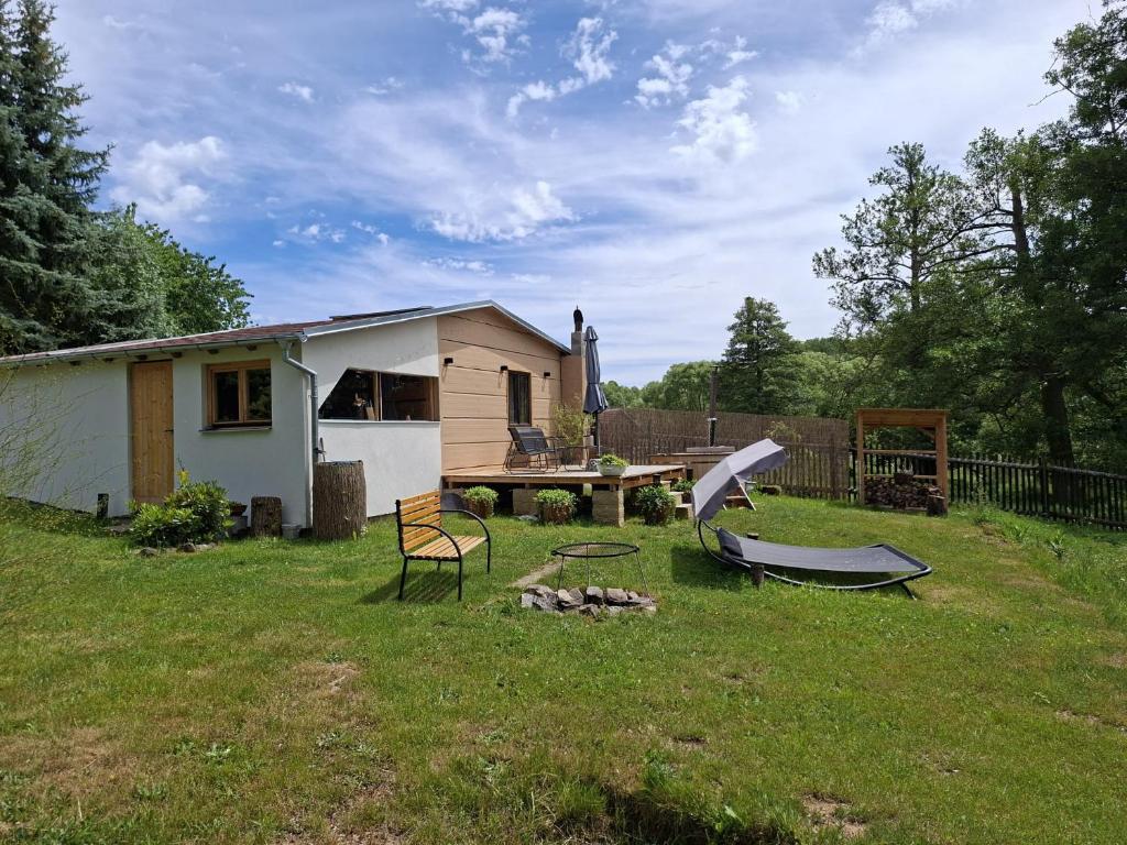 a backyard with a house and a table and a bench at Chatka U Vlka in Lnáře