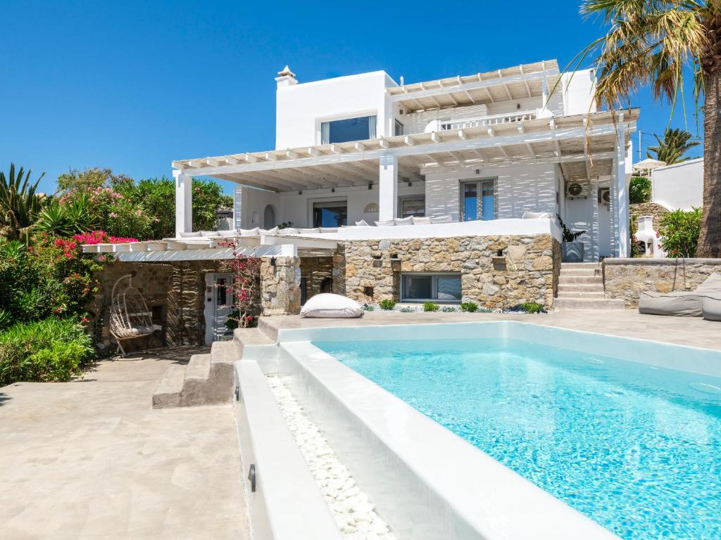a villa with a swimming pool in front of a house at myMykonos villa II in Platis Gialos