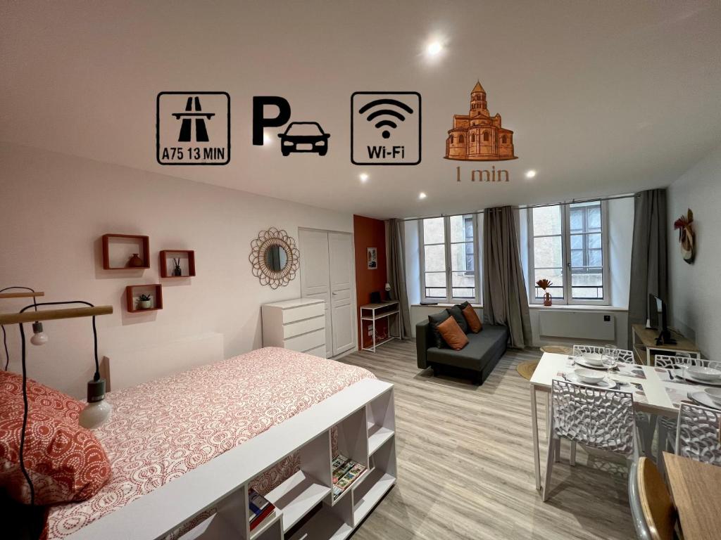 a bedroom with a bed and a living room at L'Orangeraie in Brioude