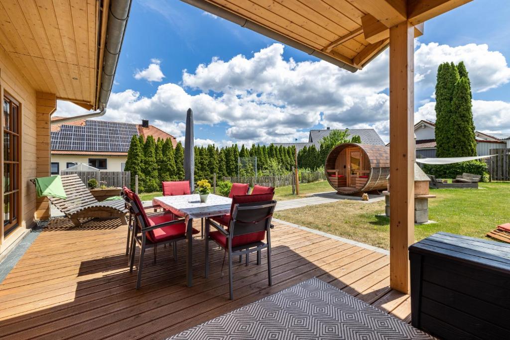 a patio with a table and chairs on a deck at Ferienhaus Traum Teufel in Hettingen