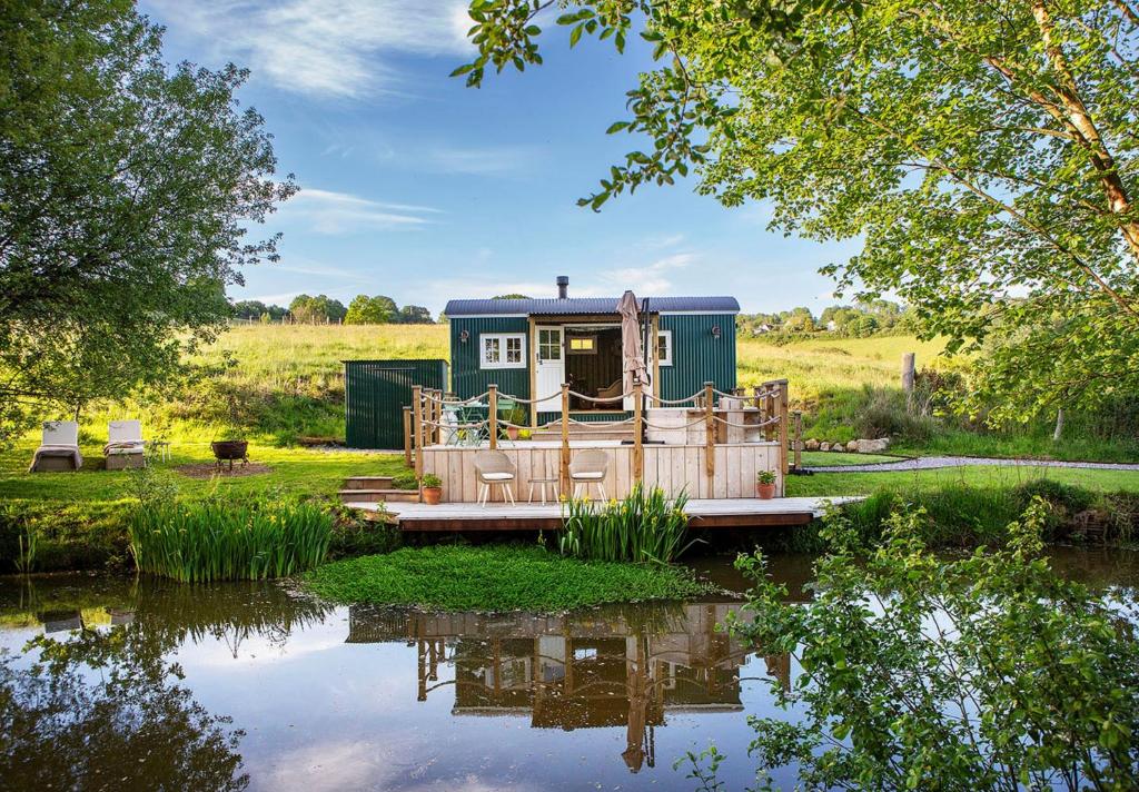 a house sitting on top of a body of water at Melbury Hut in Shaftesbury