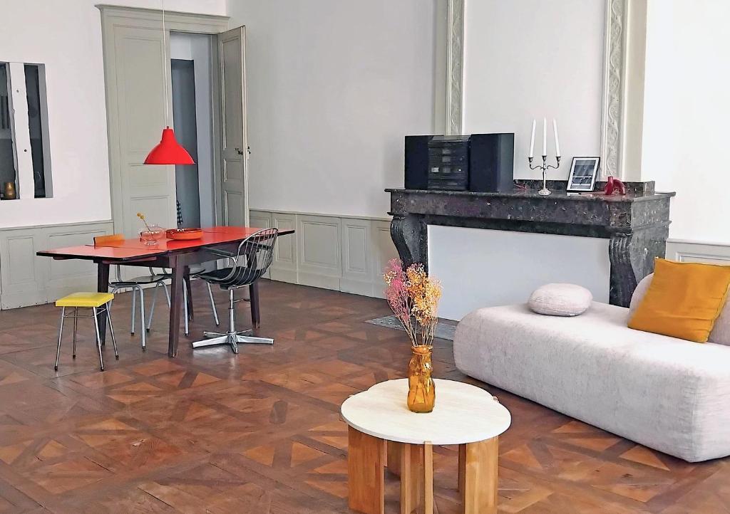 a living room with a couch and a table at Orphé37, grand appartement cocon au cœur de la Gascogne artistique in Lectoure