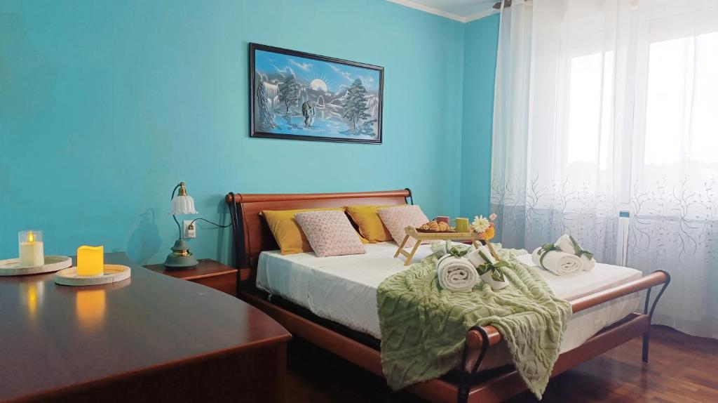 a bedroom with blue walls and a bed with a table at Dimora Euganea by Ca-Sa Check in Monselice