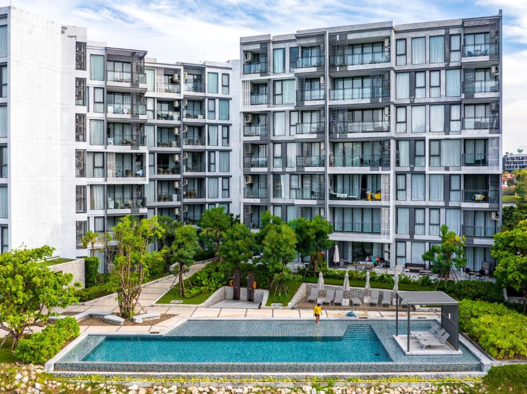 an apartment building with a pool in front of it at Cassia Residence by Metrika, Laguna Phuket in Laguna Phuket