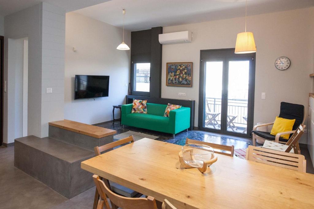 a living room with a table and a green couch at Brand-New Spacious 3 Bd Apt in Piraeus in Piraeus