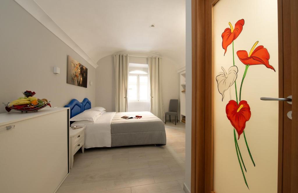 a bedroom with a bed with red flowers on the wall at Hotel Priscilla in Rome