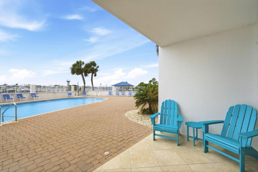 two blue chairs sitting next to a swimming pool at SeaSpray Riverside 112 in Perdido Key