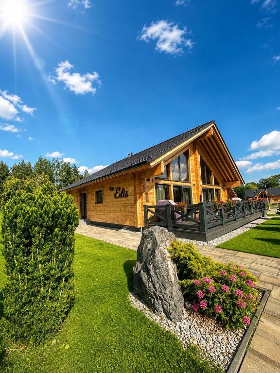 a log cabin with a rock in front of it at Vila Elis in Veľká Lomnica