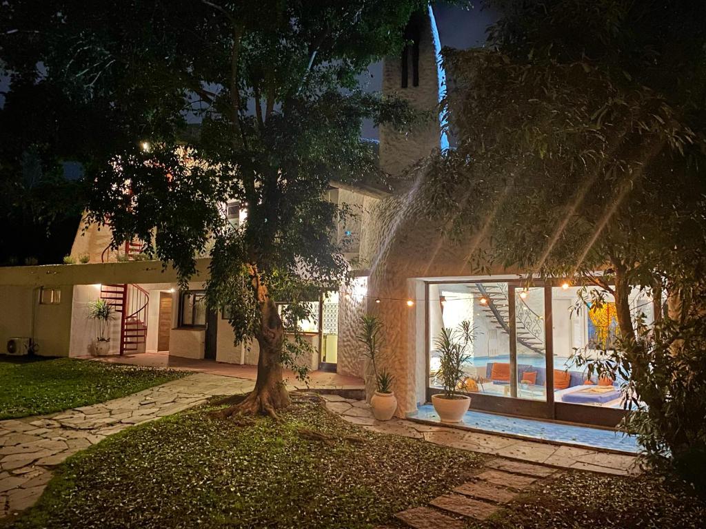 a house with a water fountain in front of a tree at Posada PuntaDelEste in Punta del Este
