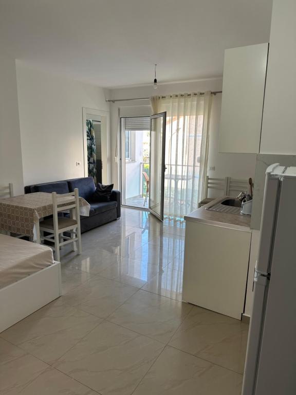 a living room with a kitchen and a living room with a couch at Leo Apartments in Lezhë