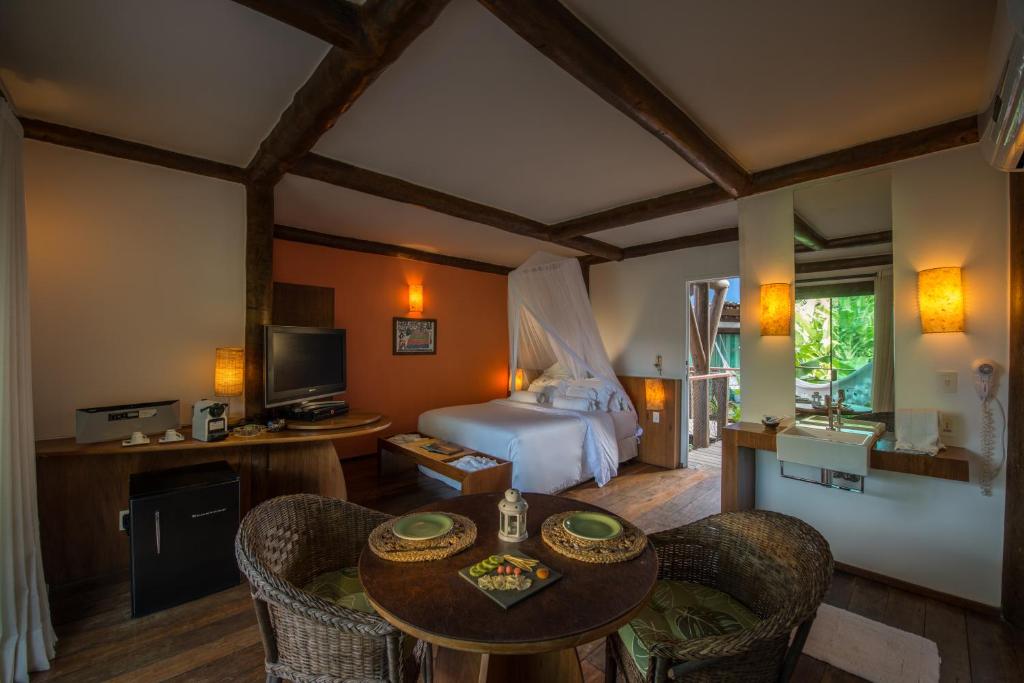 une chambre avec un lit, une table et des chaises dans l'établissement Teju-Açu Ecopousada, à Fernando de Noronha