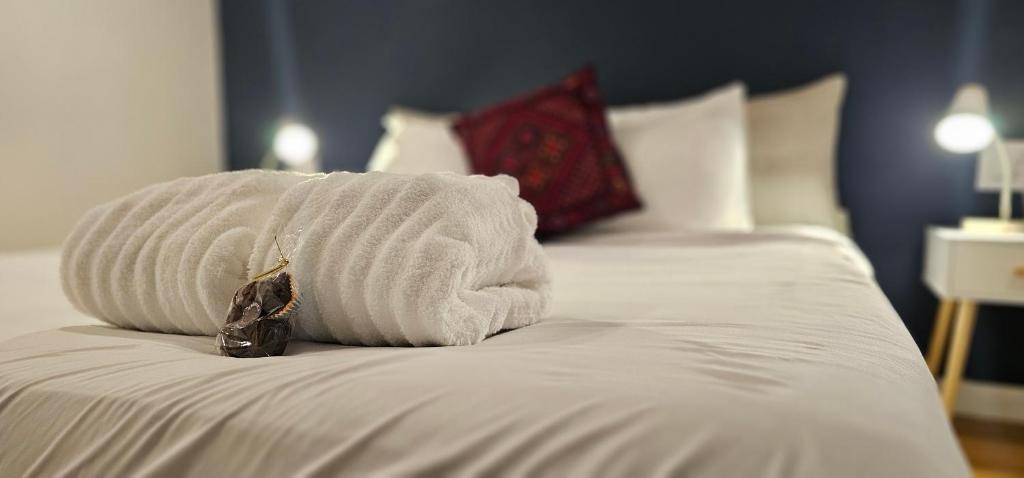 a white towel sitting on top of a bed at Hibiscus Suite - Private Studio Apartment in Rhinebeck Village in Rhinebeck