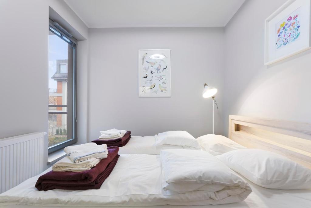 ヴロツワフにあるSpokojny i komfortowy apartament wśród zieleniの白いベッド(白いシーツ、タオル付)