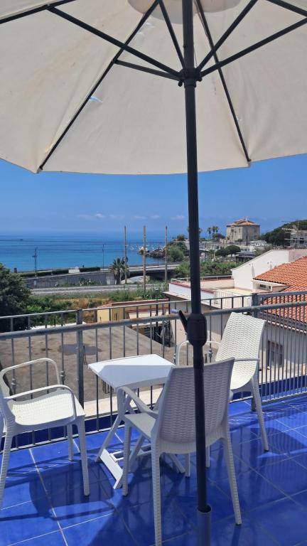 a table and chairs on a balcony with an umbrella at La Marinella in Belvedere Marittimo