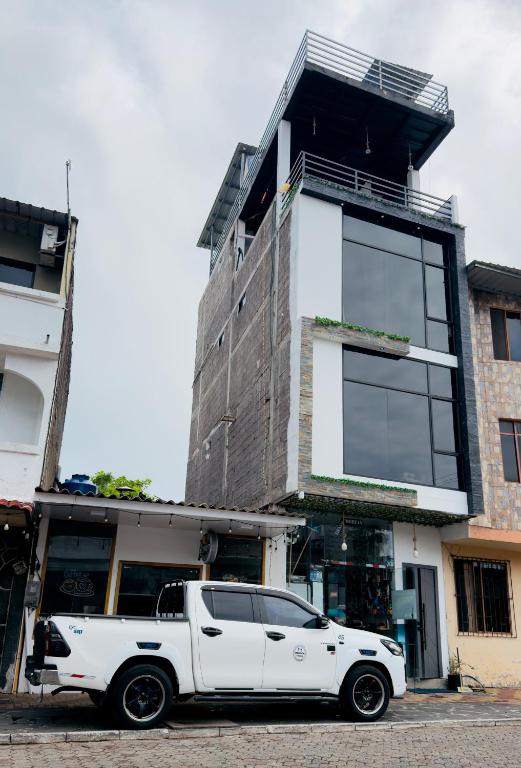 a white truck parked in front of a building at La Casa D Juan in Puerto Baquerizo Moreno