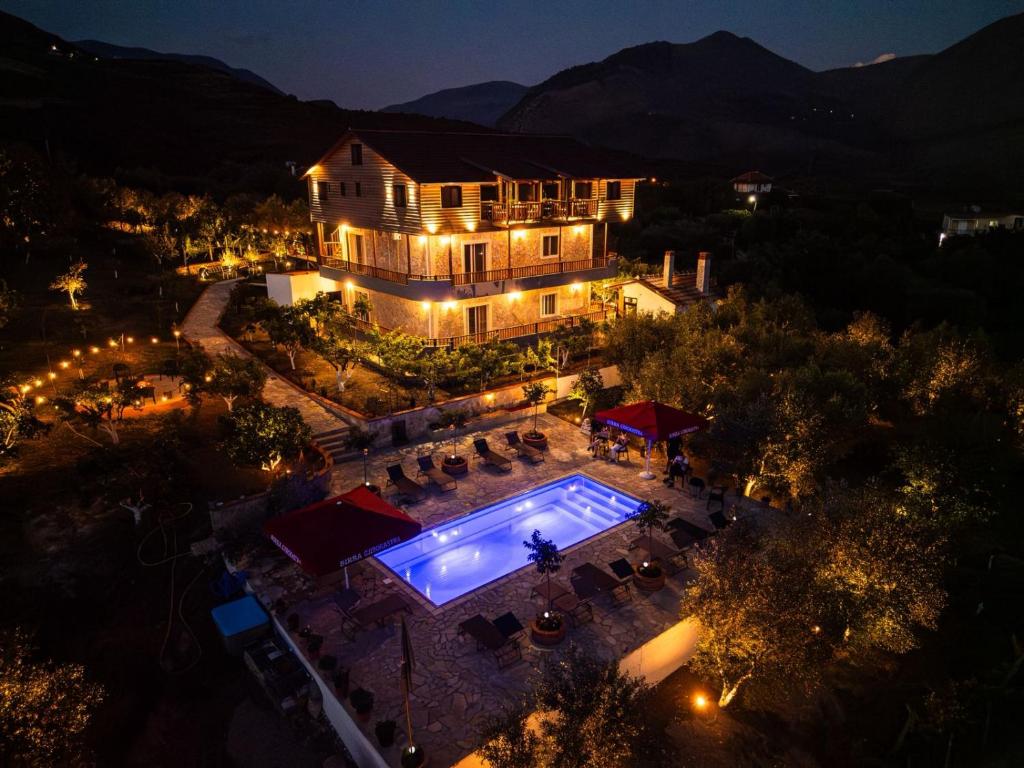 an aerial view of a house with a swimming pool at night at Shena The Farm Boutique in Mesopotam