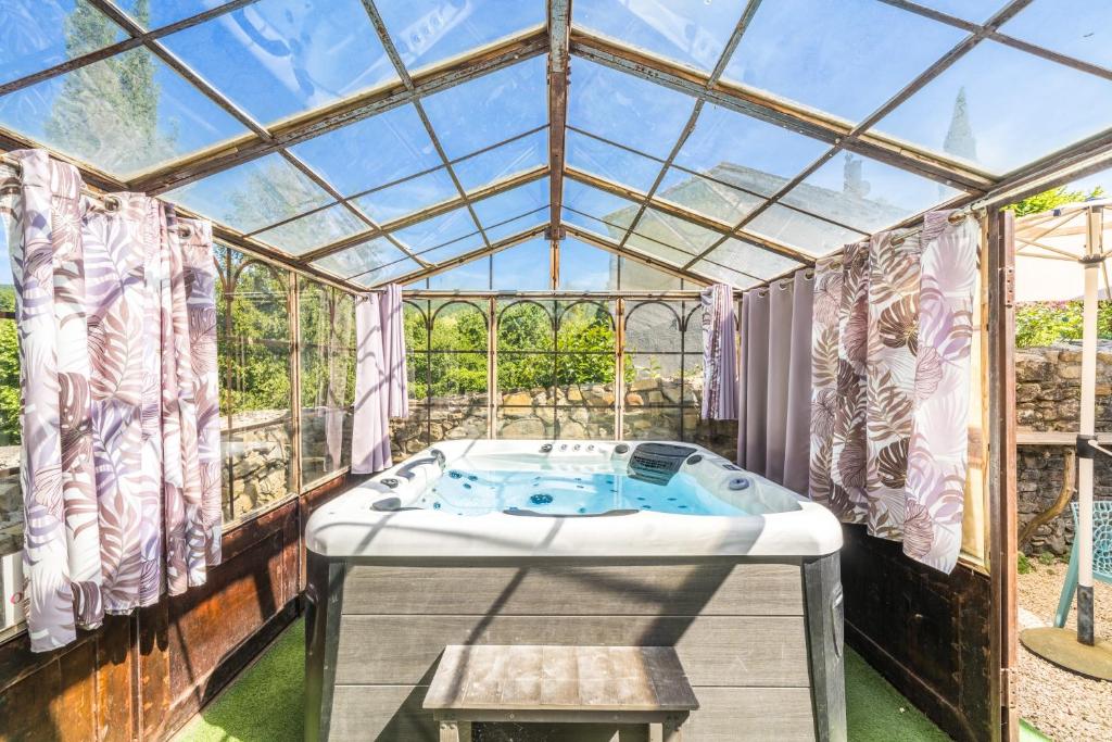 a hot tub in a glass house with a window at Le Cocon - Grospierres in Grospierres