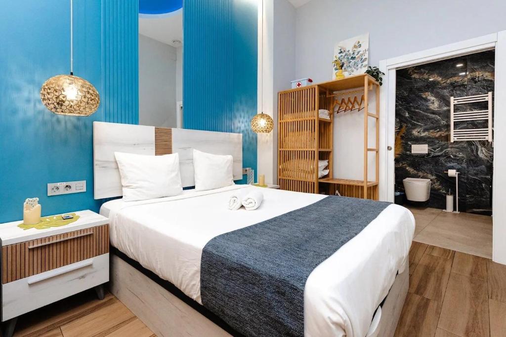a bedroom with a large bed and a blue wall at Lounge garden sea relax in Valencia