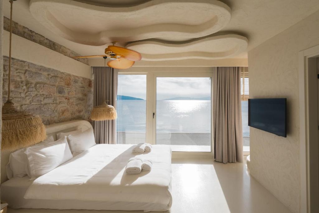 a bedroom with a white bed with a large window at YU Townhouse in Bodrum City