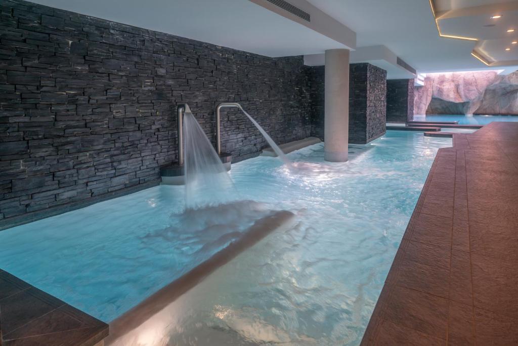 a large swimming pool with a water fountain at Le Kaïla in Méribel