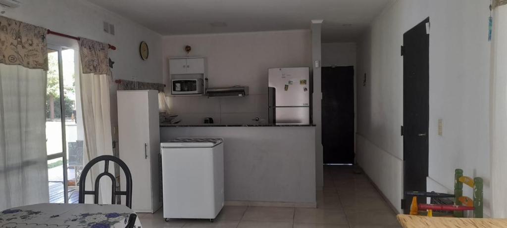 a kitchen with white appliances in a room with a table at La quinta de Hostal in Rosario