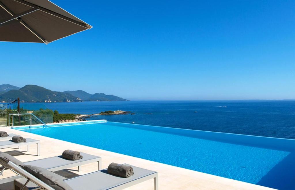 a swimming pool with a view of the ocean at White Orchid in Syvota