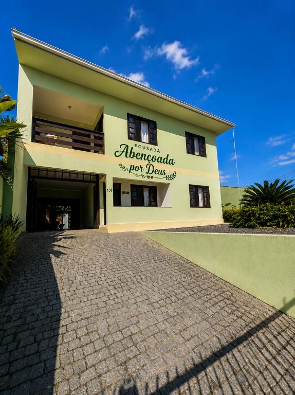 a building with a brick driveway in front of it at Hostel e Pousada Vó Lili in Joinville
