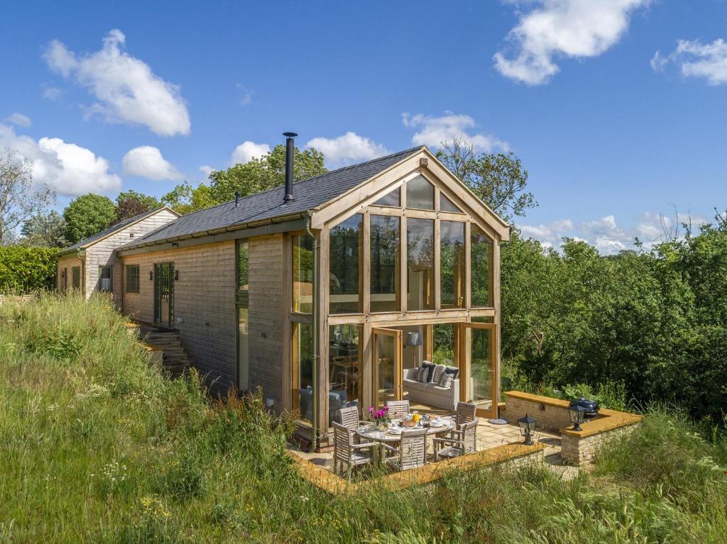 a house with a conservatory on a hill at The Tractor Shed in Combrook