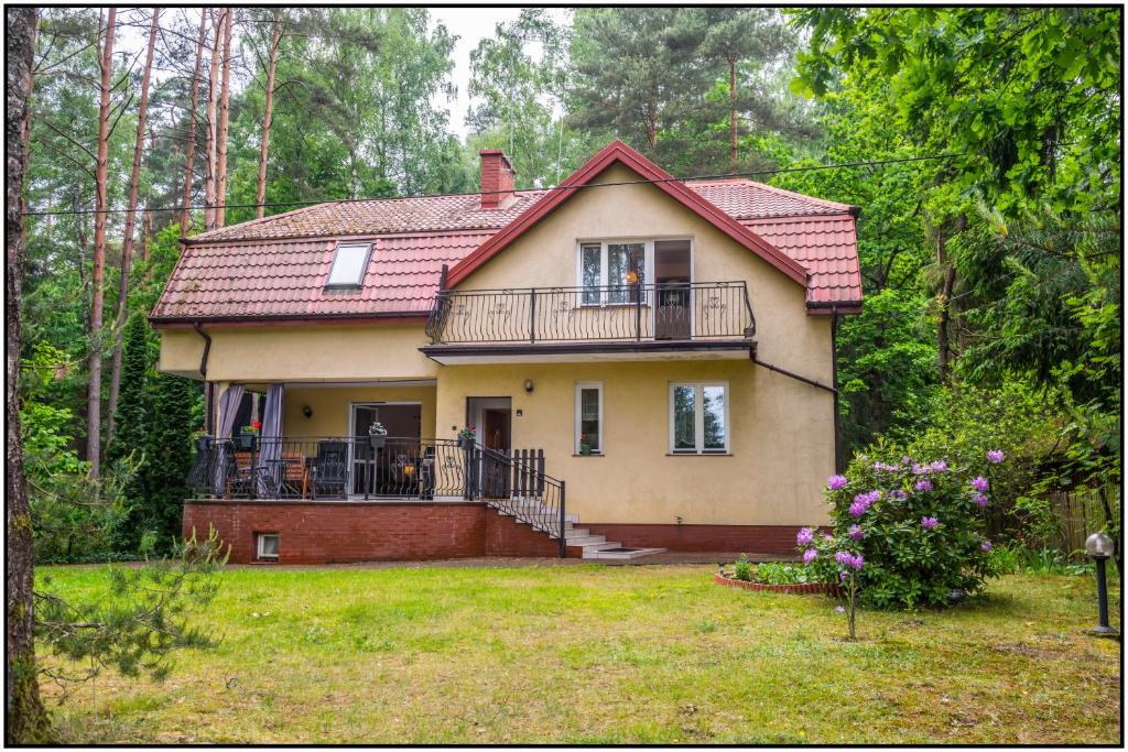 a large house with a balcony on a yard at Mazury- dom wakacyjny in Pisz