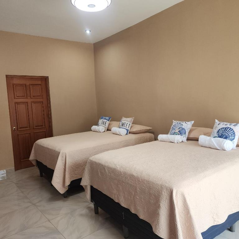 a room with two beds in a room at Vidalta Hotel Boutique in Retalhuleu