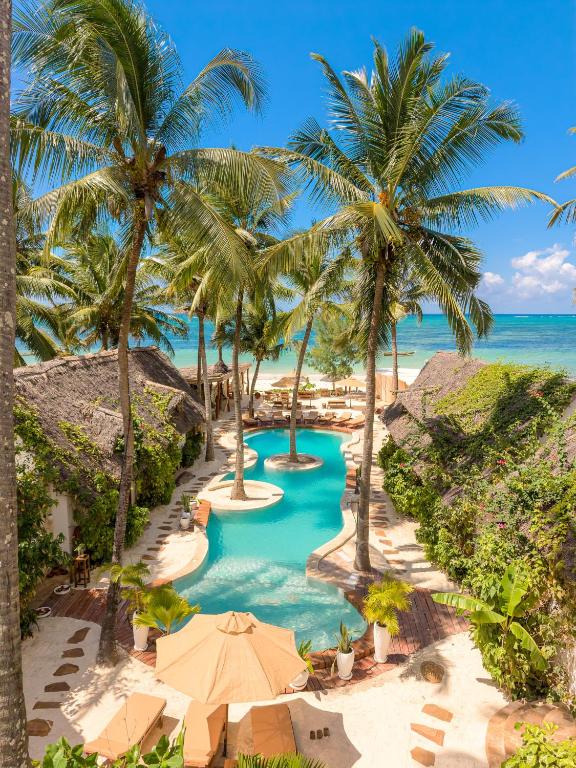 an aerial view of a resort pool with palm trees at Mala Boutique Hotel in Bwejuu