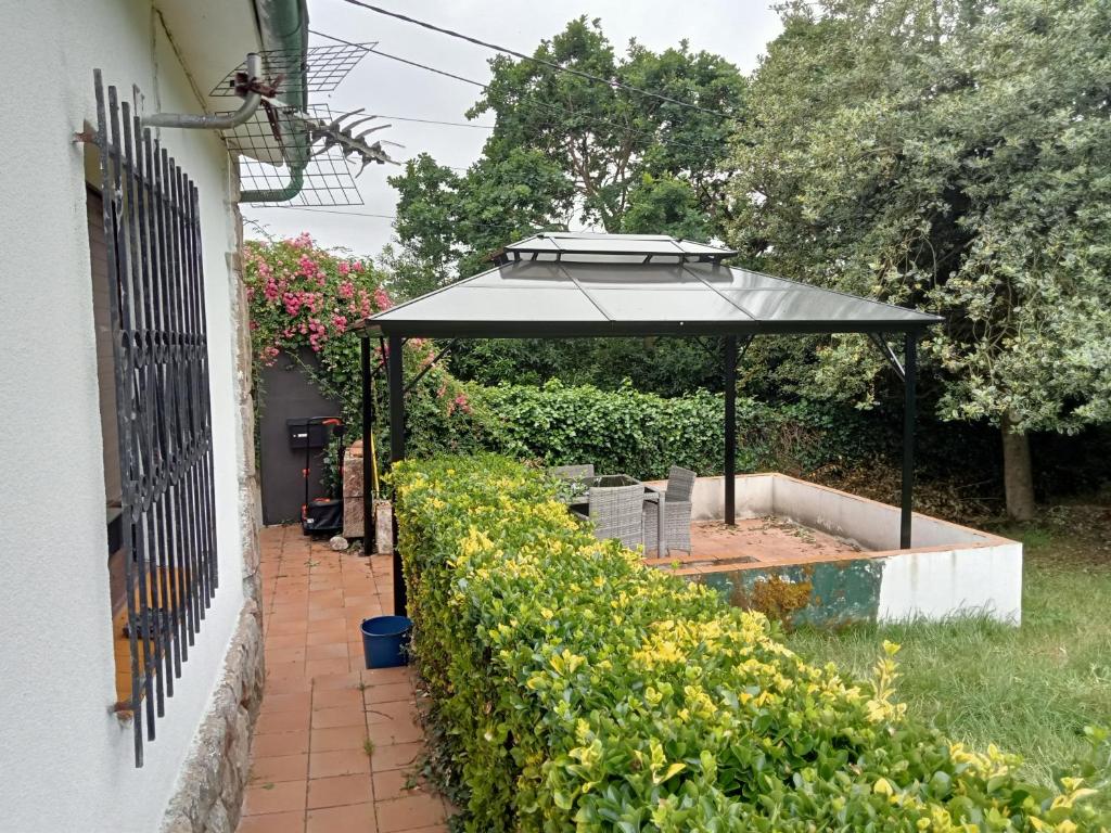 an umbrella in a garden next to a fence at El capricho de la Providencia in Gijón