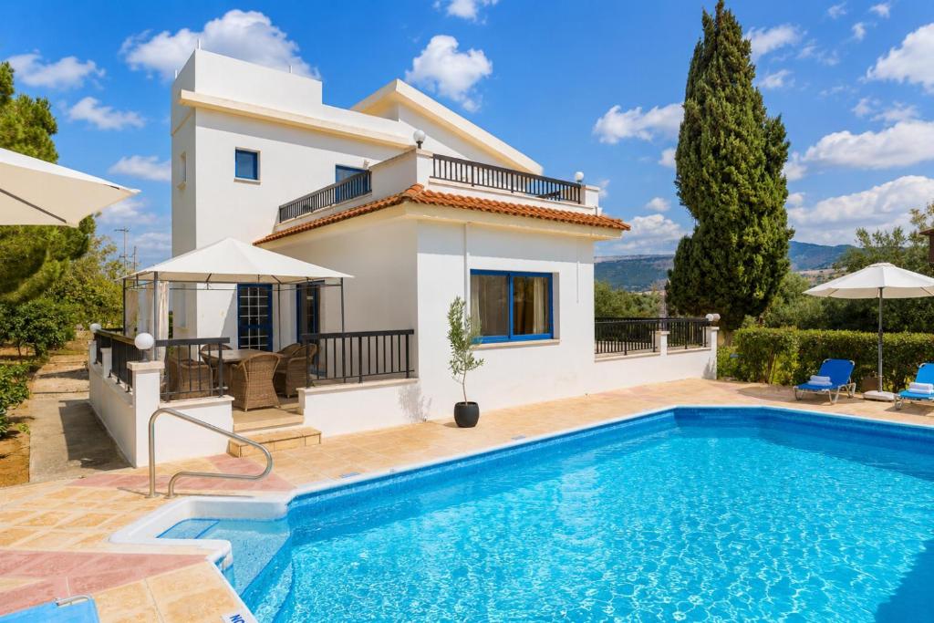 a villa with a swimming pool in front of a house at Villa Charoula Ena Large Private Pool AC WiFi in Polis Chrysochous