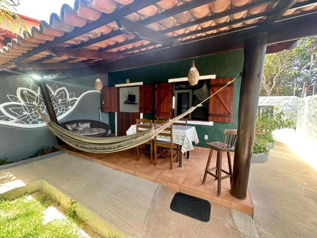 a patio with a hammock on a house at Chalé Kamala com quintal - Perfeito para Nômades Digitais in Pipa
