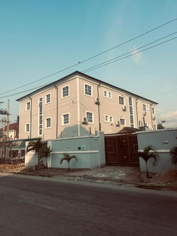 a large white building with a gate and a fence at Miad Hotels in Port Harcourt