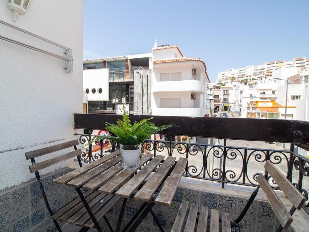 a wooden table with a potted plant on a balcony at Old Town Spot Apartment by Stay ici in Albufeira
