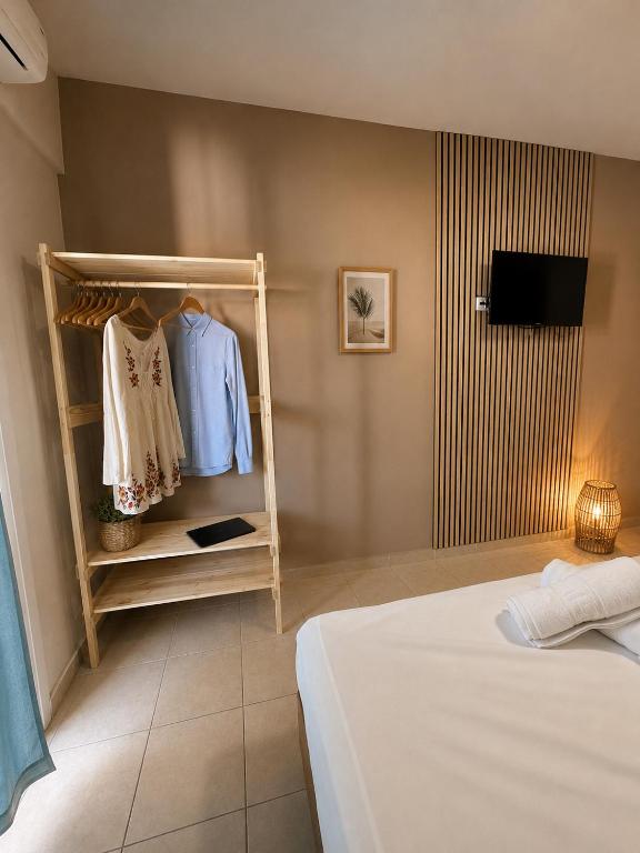 a bedroom with a bed and a tv on a wall at Meltemi Studios Polychrono in Polychrono